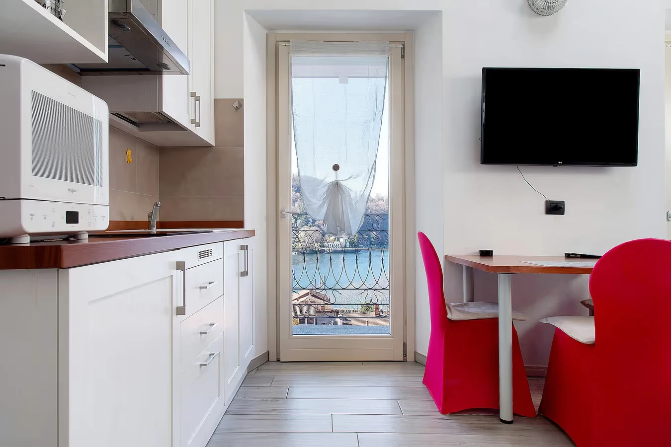 Camelia kitchen and dining area with a balcony door facing Lake Maggiore